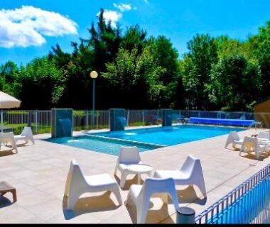 Bord de piscine avec chaises longues et parasol au Charmant Mobil home style chalet