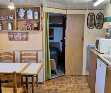 Intérieur avec coin repas et kitchenette du Charmant Mobil home style chalet