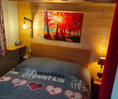 Chambre avec lit double et lambris bois dans le Charmant Mobil home style chalet