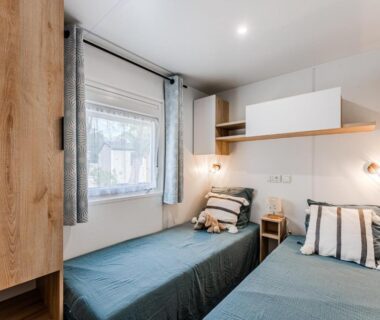 Chambre avec deux lits et fenêtre au Charmant Mobile Home Cap-Ferret