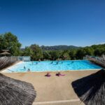 Piscine extérieure et parasols au Charmant camping Familiale 3 Etoiles vue 360