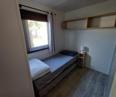 Chambre avec lit simple et fenêtre dans le Charmant mobil-home 178