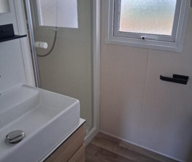 Salle de bain avec lavabo et cabine de douche dans le Charmant mobil-home N°698 3ch tout confort au calme