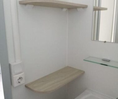 Salle d'eau avec lavabo miroir et étagères dans le Charmant mobil-home cosy 149