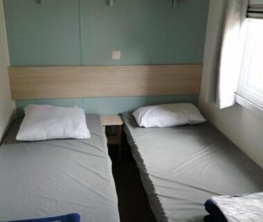 Chambre avec deux lits simples et serviettes dans le Charmant mobil-home cosy 149