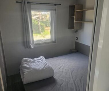 Chambre avec lit double et fenêtre dans le Charmant mobil home premium L048