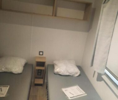 Chambre avec deux lits et fenêtre dans le mobil home Charmant mobil home premium L048