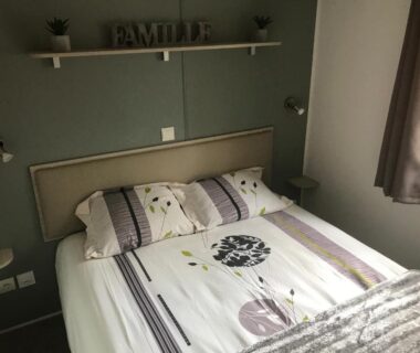 Chambre avec lit double et étagère murale au camping Chaussy55