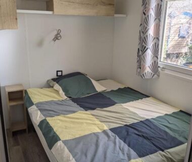 Chambre avec lit double et fenêtre dans le mobil home Chez Bruno & Sophie Mobil home luxe 6-8P BORA BORA