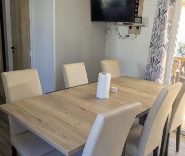 Salle à manger avec table et six chaises dans le mobil home Chez Bruno et Sophie BORA BORA