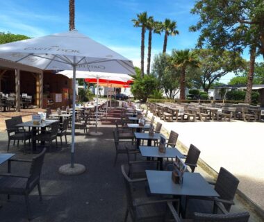 Terrasse extérieure avec tables et parasols au camping Chez Cédric et Vivi mobil home 6 pers