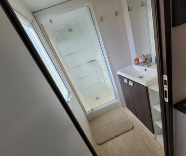 Salle d'eau avec cabine de douche et lavabo du camping Chez Coralie