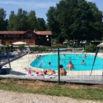 Piscine extérieure et transats au camping Chez Dom & Oli camping GINA PARK