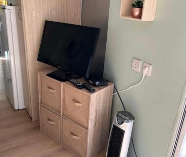 Coin séjour avec télévision et radiateur dans le logement Chez Dom & Oli camping GINA PARK
