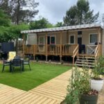 Terrasse en bois avec salon de jardin devant mobil home Chez Isa