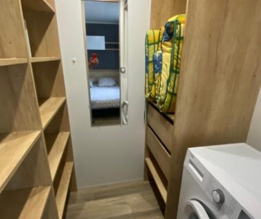 Buanderie avec lave-linge et étagères dans l'hébergement Chez Isa