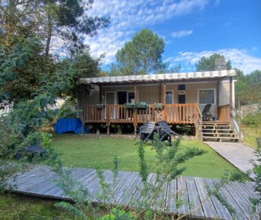Terrasse en bois et pelouse devant mobil-home dans le camping Chez Isa