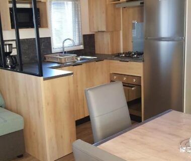 Séjour avec cuisine équipée et coin repas dans le logement Chez Loulou F77