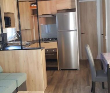 Intérieur avec coin cuisine et salon dans le mobil-home Chez Loulou F77