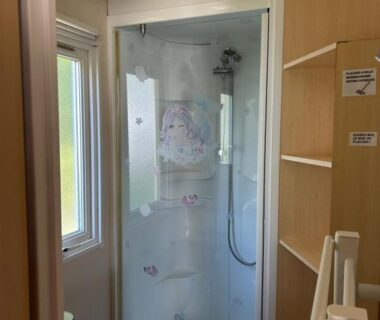 Salle de bain avec cabine de douche et lavabo dans le mobil home Chez Nathalie