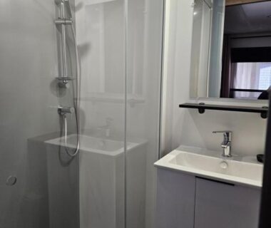 Salle d'eau avec douche vitrée et lavabo dans l'hébergement Chez Sandy et Romain