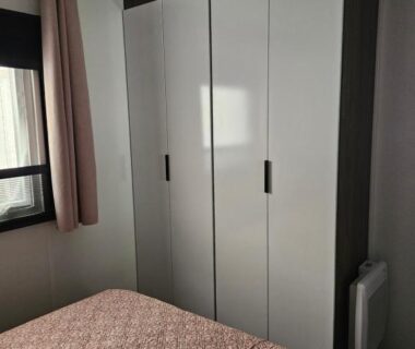 Chambre avec armoire et lit au camping Chez Sandy et Romain