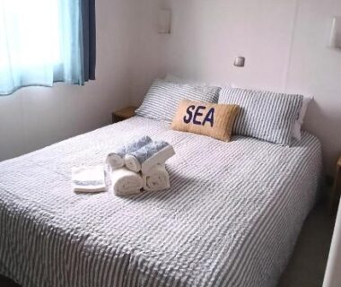 Chambre avec lit double et serviettes dans le bungalow Paisible aux Viviers Chez Seb et Sarah