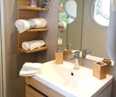 Salle de bain avec lavabo miroir et hublot dans le bungalow Chez Seb et Sarah Bungalow Paisible aux Viviers
