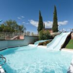 Piscine extérieure avec toboggans et fontaine au camping Chez gaby