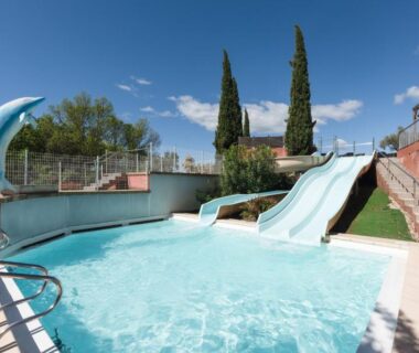 Piscine extérieure avec toboggans et fontaine au camping Chez gaby