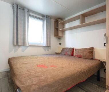 Chambre avec lit double et fenêtre dans le mobil-home du camping Chez gaby