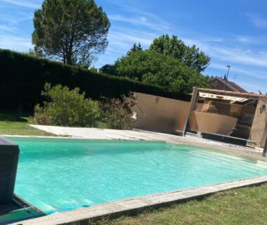 Piscine extérieure bordée de pelouse et pergola à la Chicken roulotte des 3 cèdres