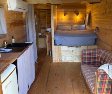 Intérieur de roulotte avec lit kitchenette et canapé dans la Chicken roulotte des 3 cèdres