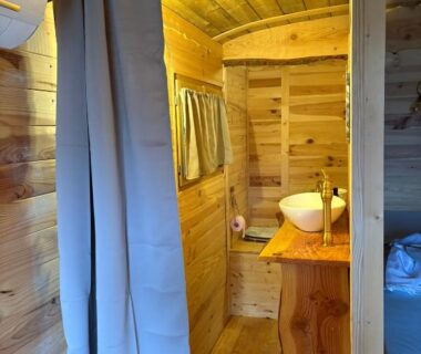 Intérieur en bois avec lavabo et rideau dans la roulotte Chicken roulotte des 3 cèdres