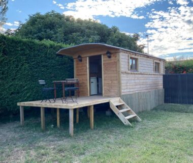 Terrasse en bois devant roulotte sur pelouse dans la Chicken roulotte des 3 cèdres