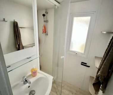 Salle de bain avec lavabo, miroir et douche dans le Clearedtochill Mobilhome 6P Camping Siblu Bois Dormant 4 étoiles