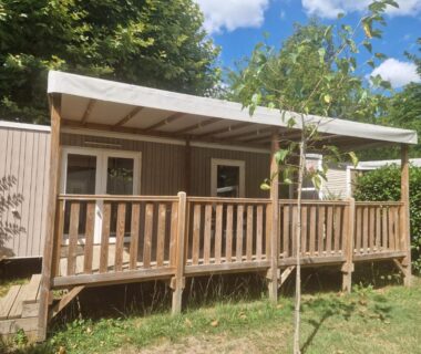 Terrasse en bois et mobil-home ombragé au camping Clim piscine animations concerts jeux enfant