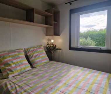 Chambre avec lit et fenêtre dans le camping Clim, piscine, animations, concerts, jeux enfant