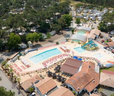Piscine extérieure avec bassins et solarium dans un camping entouré de pins au Cocon Évasion claouey Cap ferret