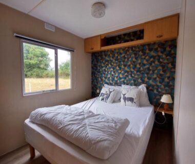 Chambre avec lit double et fenêtre dans le mobile-home Comme Chez Toi