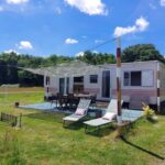 Terrasse et transats sur pelouse devant mobile-home au camping Comme Chez Toi