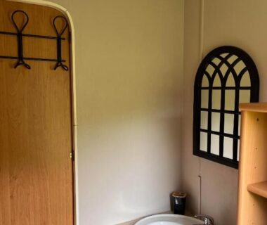 Salle d'eau avec lavabo et miroir dans le mobil-home Comme Chez Toi