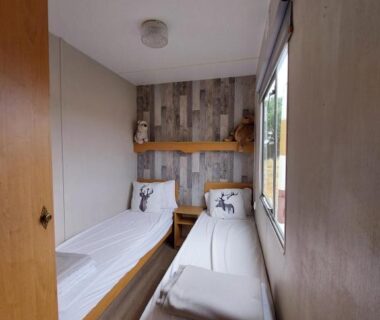 Chambre intérieure avec deux lits simples dans le mobile-home Comme Chez Toi