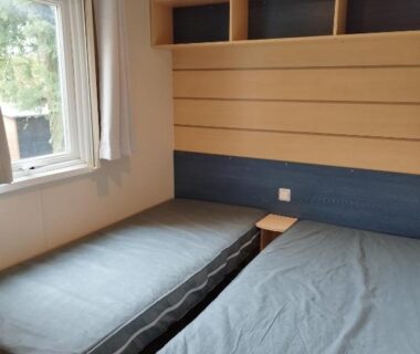 Chambre avec deux lits et fenêtre dans l'hébergement Comme Chez Vous Au Camping Des Iscles