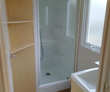 Salle d'eau avec cabine de douche et lavabo dans le logement Comme Chez Vous au Camping Des Iscles