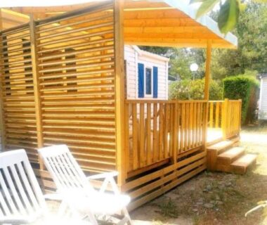 Terrasse en bois avec chaises longues au Comme Chez Vous Au Camping Des Iscles