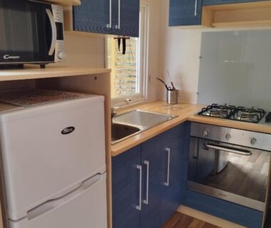 Kitchenette avec frigo micro-ondes évier et plaque de cuisson dans le mobil-home Comme Chez Vous Au Camping Des Iscles