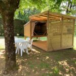 Terrasse ombragée avec abri en bois et mobilier de jardin dans le camping Cop’campétoiles