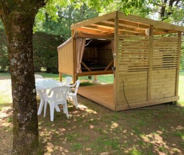 Terrasse ombragée avec abri en bois et mobilier de jardin dans le camping Cop’campétoiles