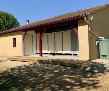 Façade et terrasse ombragée du bâtiment du camping Cop'campétoiles